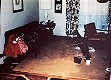 Afghan comforter on couch in living room, after items from steps were placed on couch by investigators